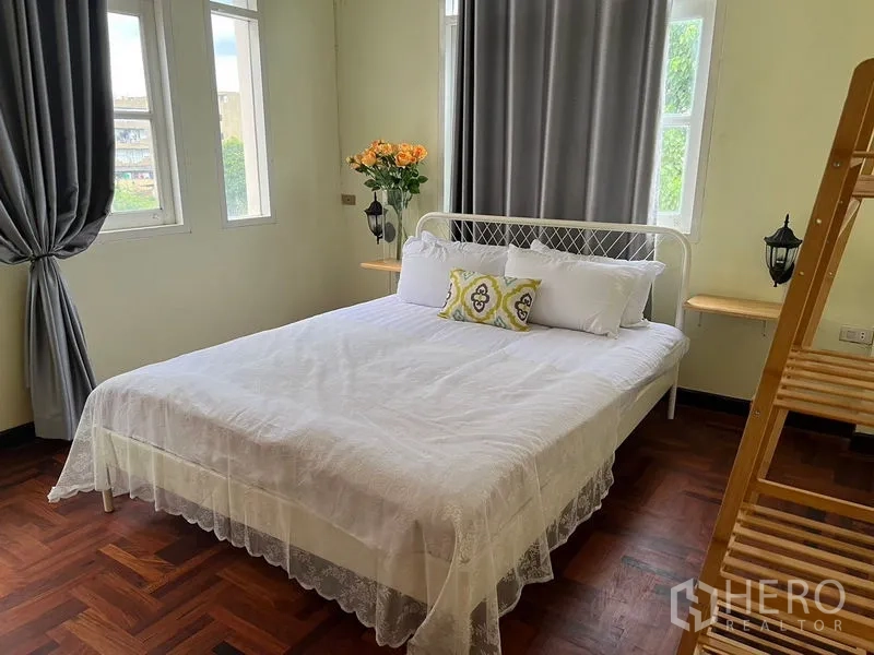 带办公室的家 出租在Suan Luang, Bangkok - 阳光卧室，配床、木质置物架和多扇窗