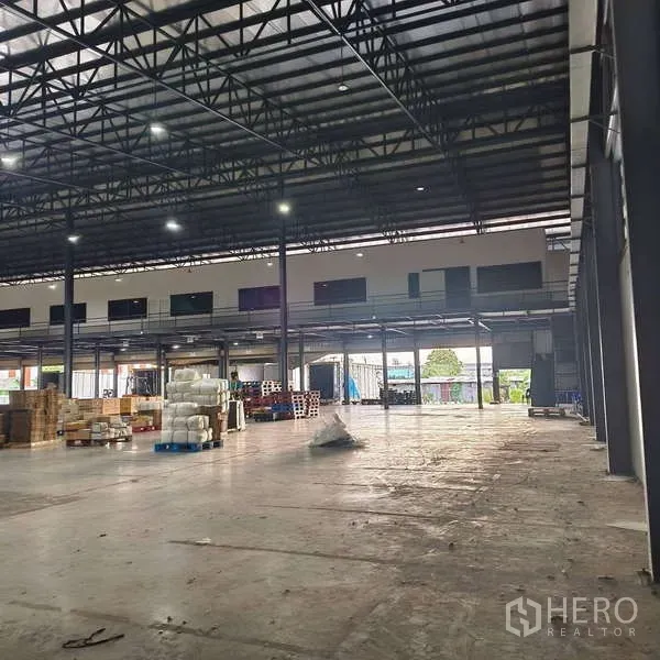 货栈 出租在Samut Prakan - 高净空仓库内部，钢结构屋架，带夹层及办公室窗户。