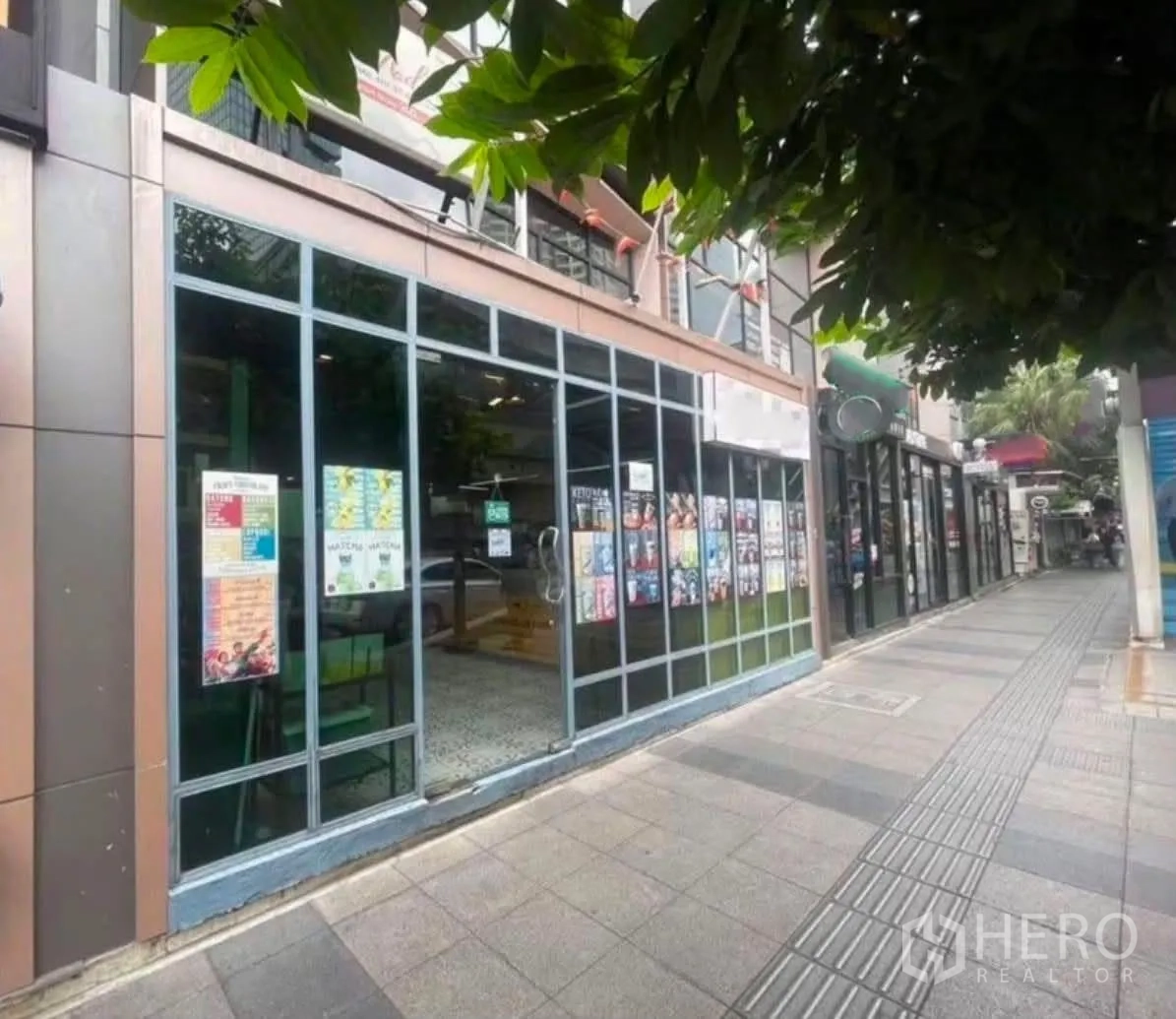 Retail Space for rent in Bang Rak, Bangkok - Street-level retail unit with full-height glass windows and door along a shaded walkway with neighboring shopfronts.