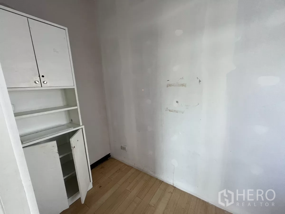 Retail Space for rent - Compact storage room with white built‑in cabinet and open shelves.