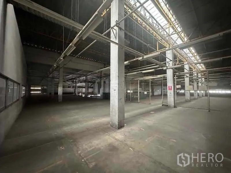 Factory for rent in Khlong Luang, Pathum Thani - Warehouse bay with skylights, tall columns and hanging utility lines