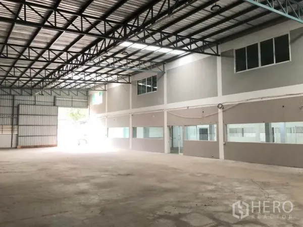 货栈 出租在Khlong Sam Wa, Bangkok - 明亮仓储大厅，钢梁结构，大型卷帘门与玻璃办公区。
