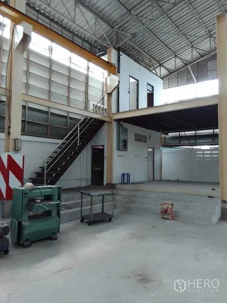 Warehouse for rent in Mueang Samut Prakan, Samut Prakan - Warehouse interior showing mezzanine office, staircase and high, ventilated roof.