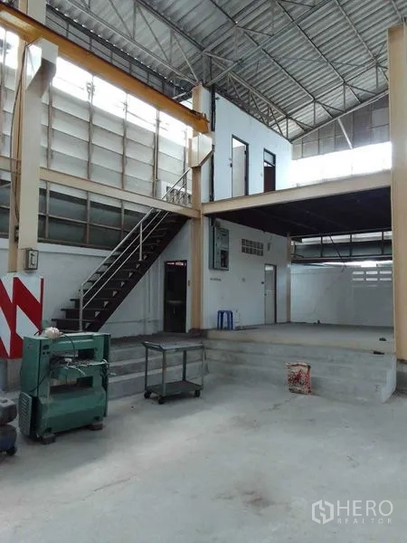 Warehouse for rent in Mueang Samut Prakan, Samut Prakan - Warehouse interior showing mezzanine office, staircase and high, ventilated roof.