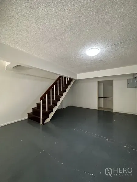 Retail Space for rent in Watthana, Bangkok - Ground-floor retail area with staircase, storage room, and smooth concrete floor.