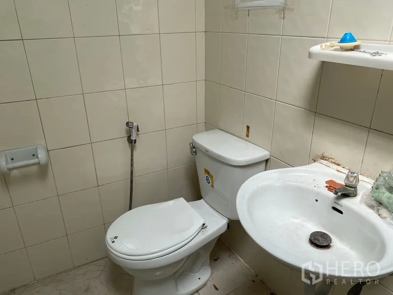 货栈 出租在Chatuchak, Bangkok - 瓷砖卫生间，坐便器与洗手盆及喷枪。