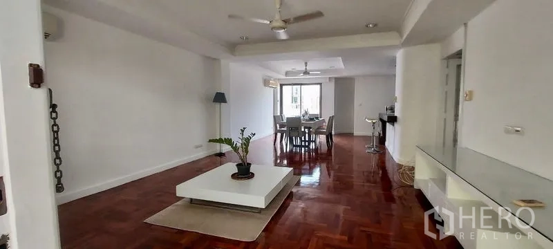 Townhouse for rent in Sathon, Bangkok - Spacious open-plan living and dining room with polished hardwood floors and ceiling fans.