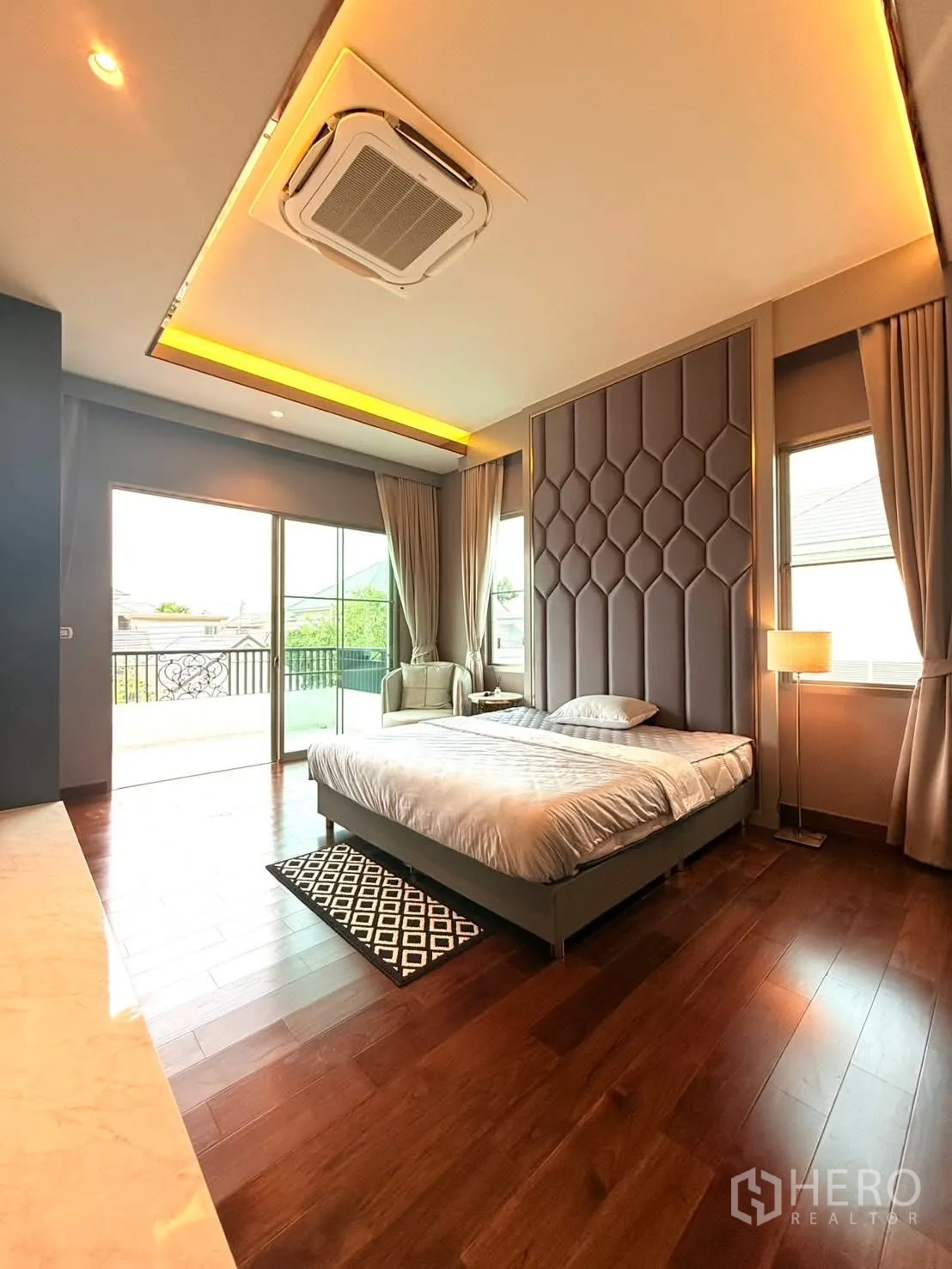 Detached House for rent or sale in Bang Phli, Samut Prakan - Master bedroom with statement headboard, ceiling cassette AC, balcony access and wooden floors.