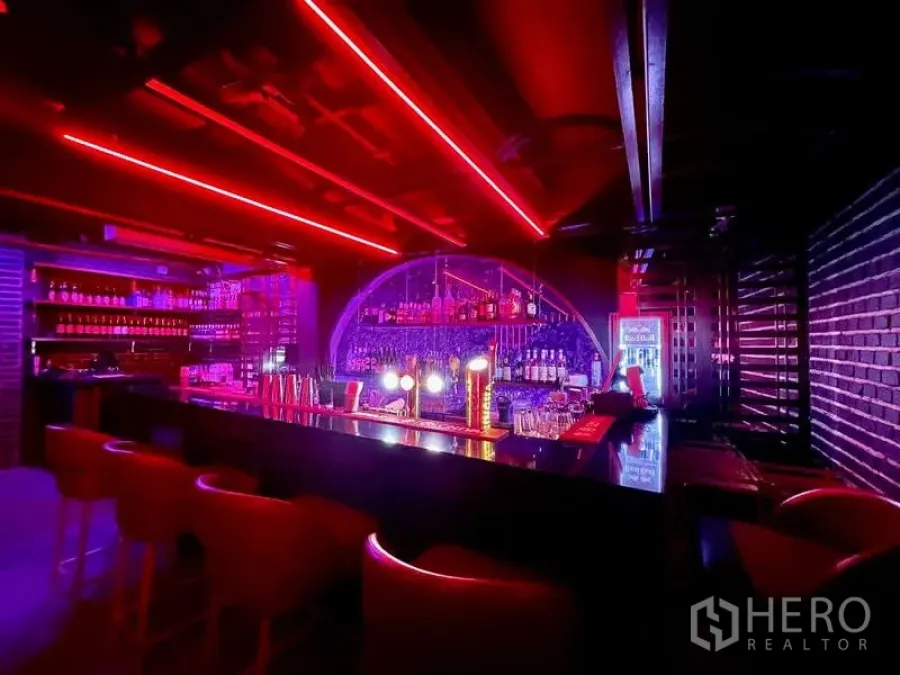 Retail Space for rent in Bangkok - Backlit bar counter with shelves of bottles and red strip lights.