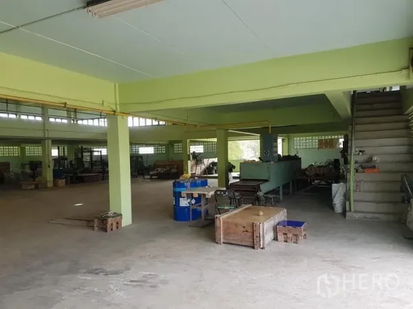 工厂 出租或出售在Nong Chok, Bangkok - 一层开放式车间，混凝土地面、结构立柱、管线到位，并有楼梯通往上层。