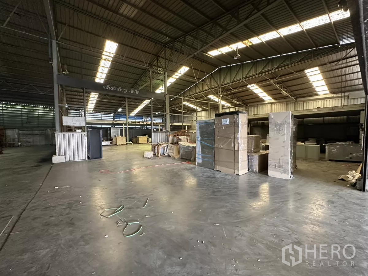 Warehouse for rent in Yan Nawa, Bangkok - Large warehouse interior with high steel truss roof and skylights over open floor space.