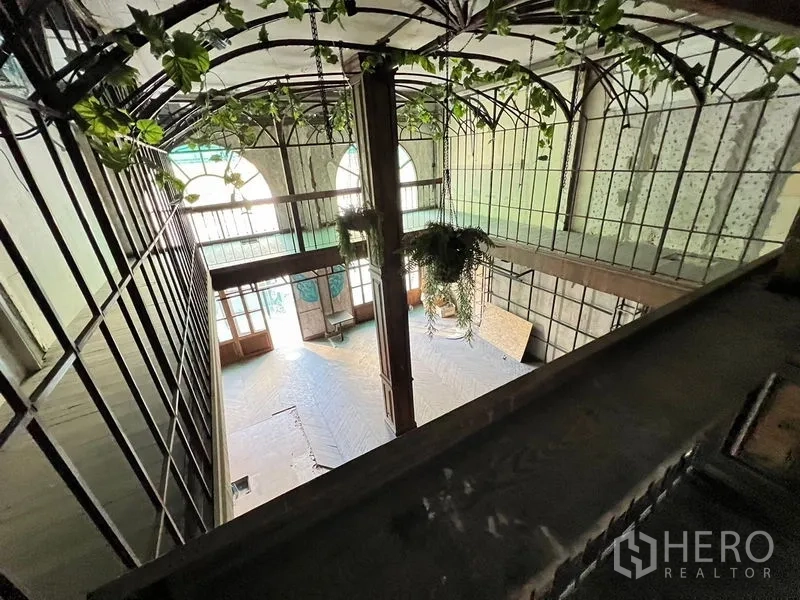 อาคารพาณิชย์ ให้เช่าในWatthana, Bangkok - มุมมองชั้นบนลงสู่โถงสูงโปร่ง พร้อมกระจกและงานจัดสวนแขวน.