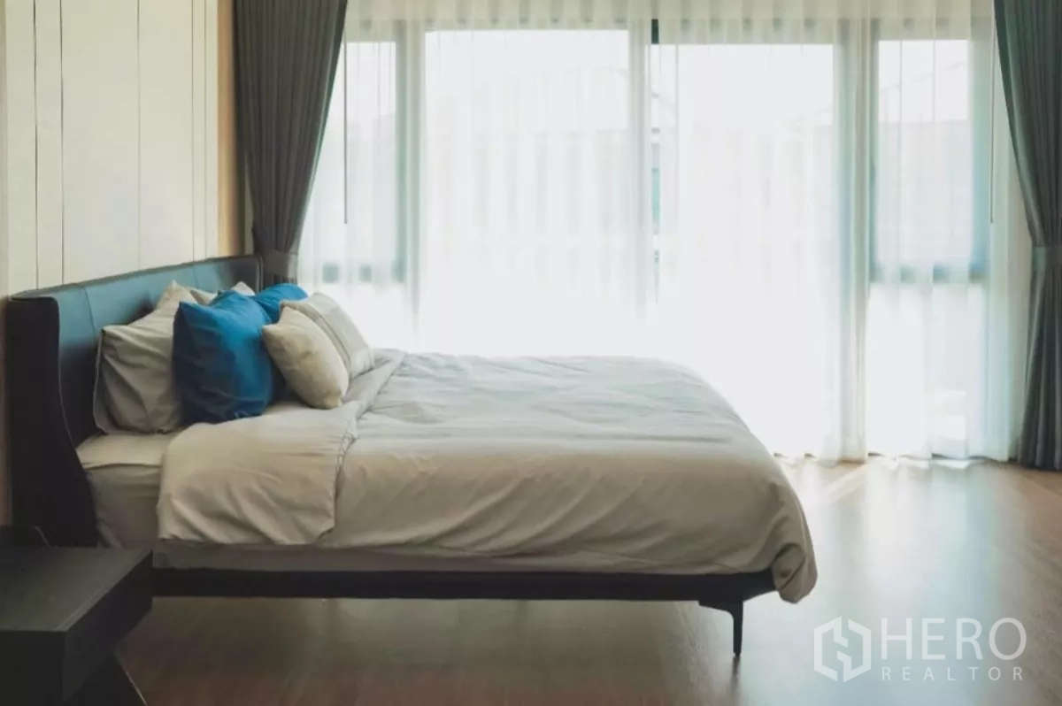 Detached House for rent in Bang Phli, Samut Prakan - Spacious bedroom with king bed and a wall of glass opening to the balcony.
