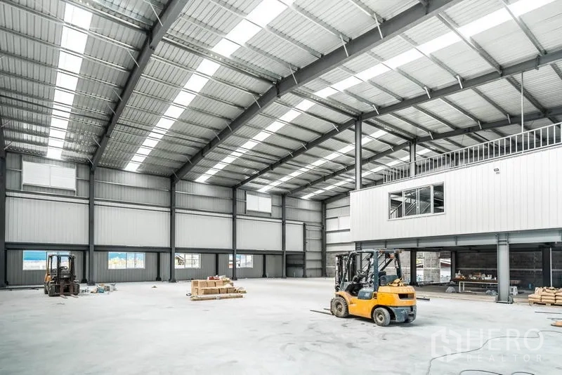 Warehouse for rent in Lat Krabang, Bangkok - Spacious warehouse interior with high-clear steel roof, skylight panels, smooth concrete floor and forklifts.