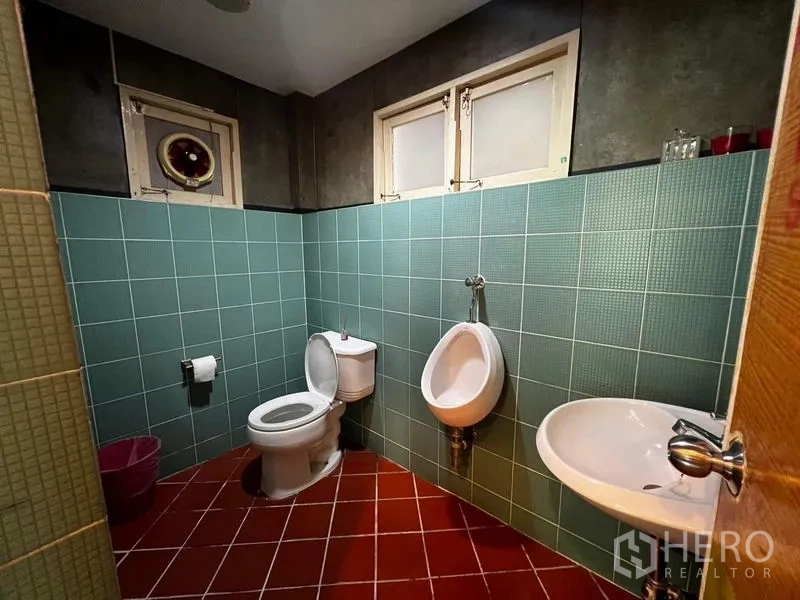 Townhouse for rent - Second tiled bathroom with green wall tiles, toilet, urinal and sink.