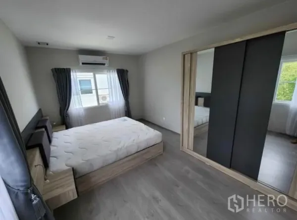Detached House for rent in Prawet, Bangkok - Bedroom with double bed, mirrored sliding-door wardrobe, air conditioner, and two windows.