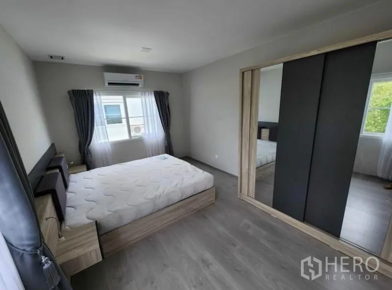 Detached House for rent in Prawet, Bangkok - Bedroom with double bed, mirrored sliding-door wardrobe, air conditioner, and two windows.
