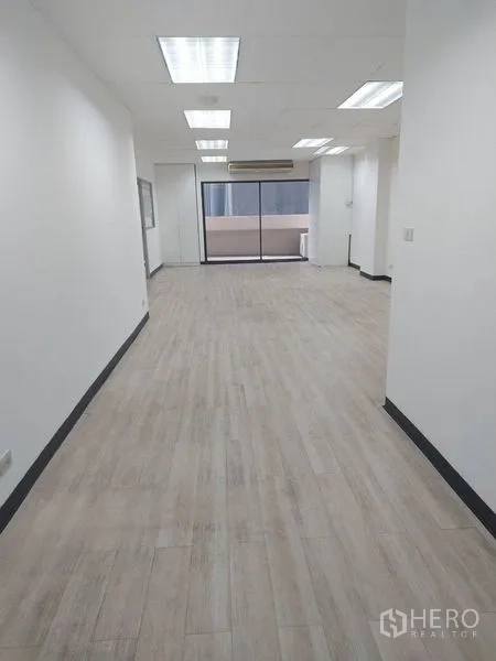 办公空间 出租在Pathum Wan, Bangkok - 采光良好的开放式办公室，木纹地板，嵌入式灯具，推拉玻璃门通向阳台。
