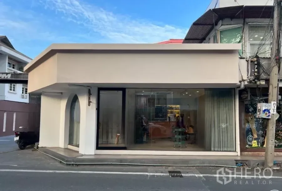 Retail Space for rent - Corner retail unit with beige facade and full-height glass frontage on a Thonglor side street.