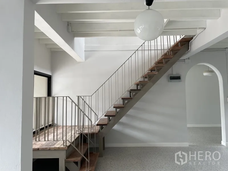 Home Office for rent in Khlong Toei, Bangkok - Open-tread wooden staircase in a double-height living or work area
