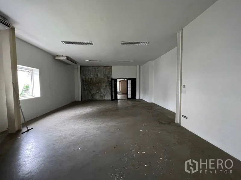 Retail Space for rent - Empty back-of-house room with white walls, air-conditioning units and concrete flooring.