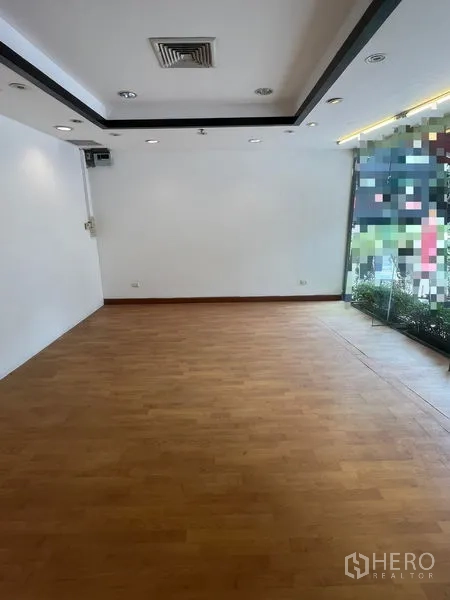 零售空间 出租在Pathum Wan, Bangkok - 室内空铺，木地板、白墙、筒灯与吊顶出风口。