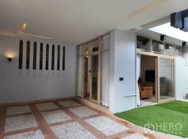 Townhouse for sale - Covered carport and patio with skylight, artificial lawn and sliding glass doors.