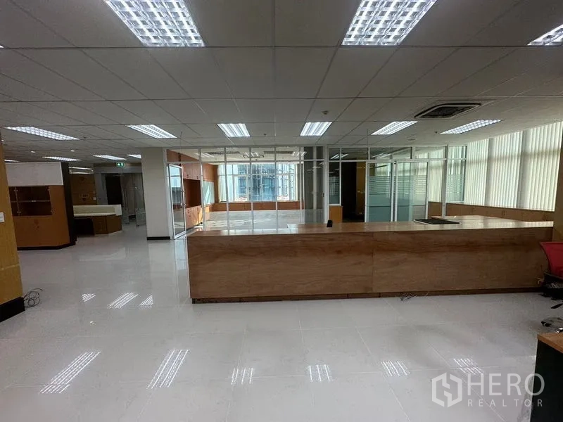 Office Space for rent in Suan Luang, Bangkok - Spacious office reception area with wood counter, glass partitions and fluorescent lighting