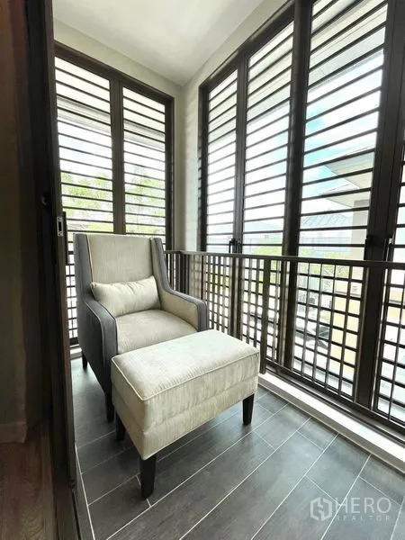 Detached House for rent in Bang Kapi, Bangkok - Enclosed balcony nook with armchair and ottoman behind louvered panels.