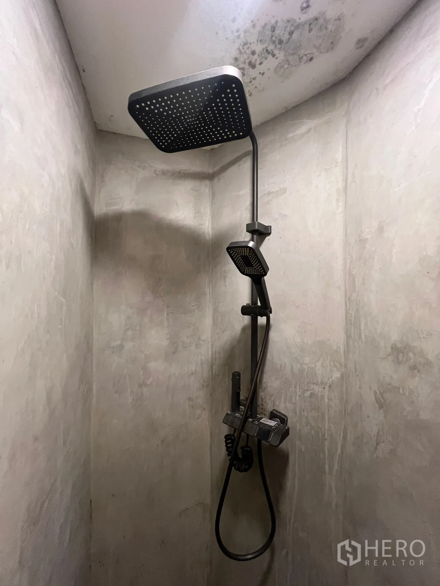 Retail Space for rent in Khlong Toei, Bangkok - Concrete shower stall with black rainfall shower and handheld sprayer.