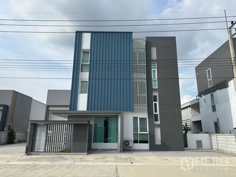 Factory for sale in Lam Luk Ka, Pathum Thani - Modern three-storey office facade of a new factory in Lam Luk Ka within a secure compound.