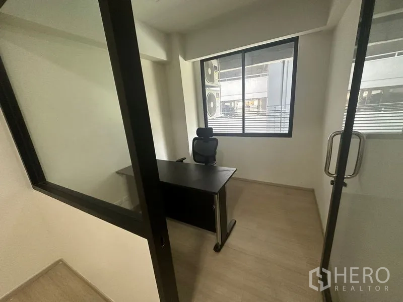 Office Space for rent in Khlong Toei, Bangkok - Private manager’s office with a black desk and ergonomic chair behind a glass door and window.