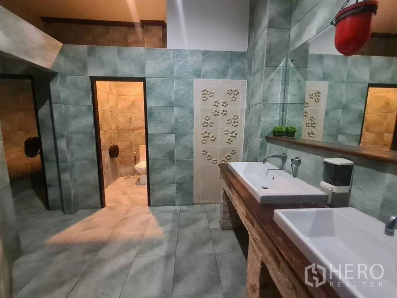 Retail Space for rent in Watthana, Bangkok - Restroom finished in green tiles with double rectangular sinks, mirror and two toilet cubicles.