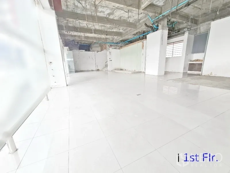 店屋 出租在Bang Na, Bangkok - 一层零售空间，外露管线天花，抛光地砖与宽玻璃门面。