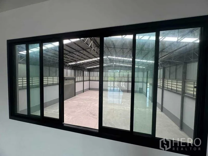 Factory for sale in Samut Sakhon - Office window looking over the warehouse floor and loading door area.