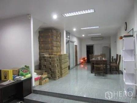 带办公室的家 出租或出售在Wang Thonglang, Bangkok - 宽敞开放区，有餐桌与堆放的储物箱。