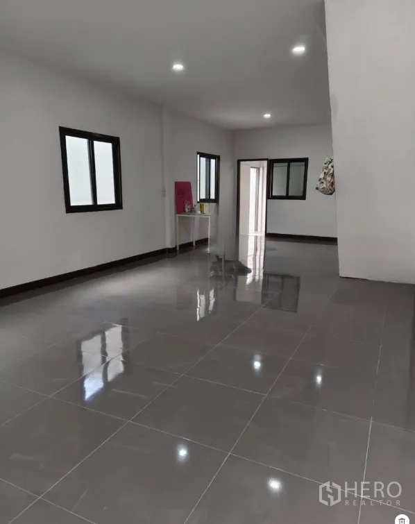 Townhouse for sale in Phra Khanong, Bangkok - Open-plan lounge with multiple windows and a doorway to the rear.