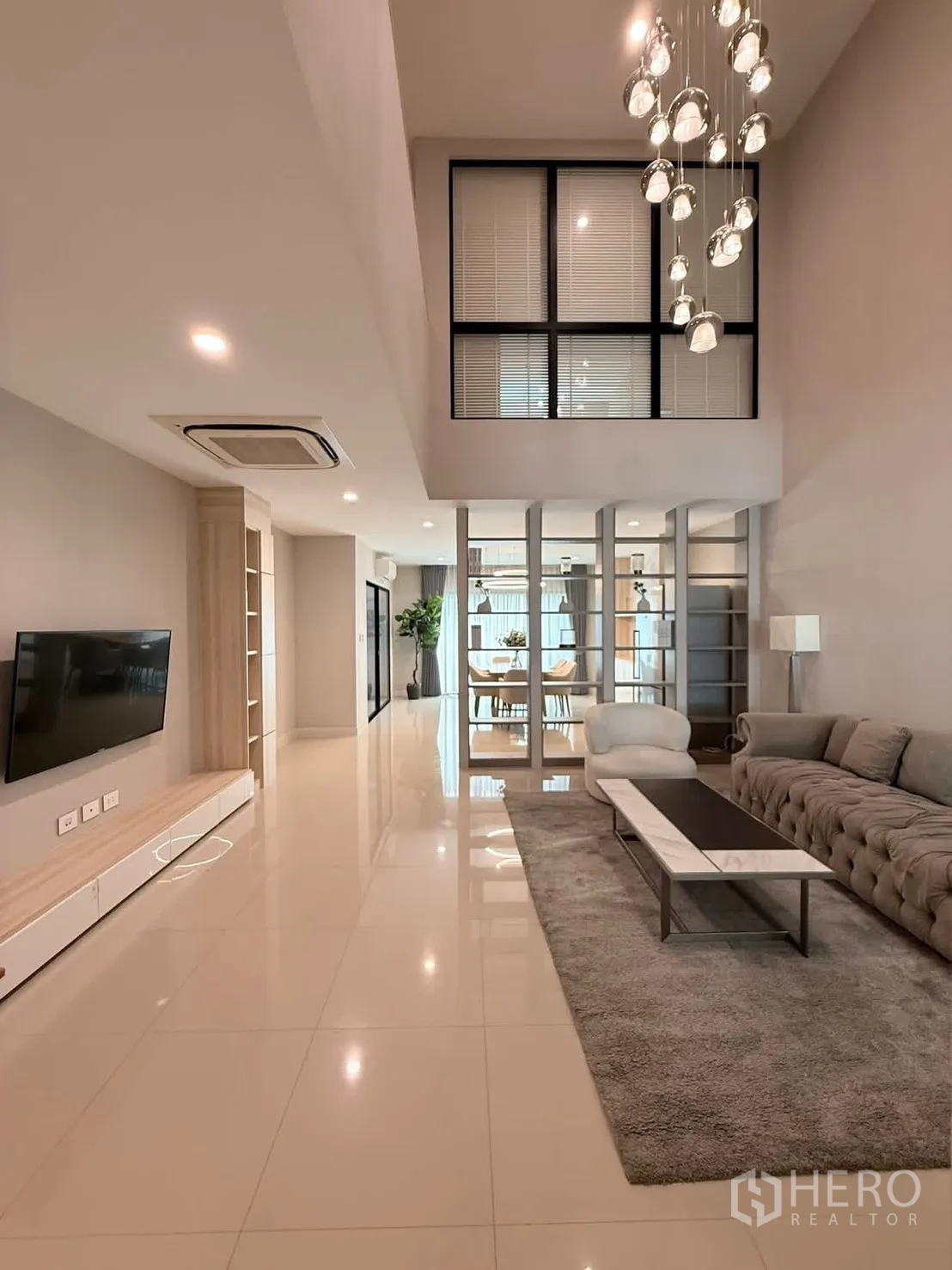 联排别墅 for rent in Saphan Sung, Bangkok - 挑高客厅，水晶吊灯、沙发组与电视墙。