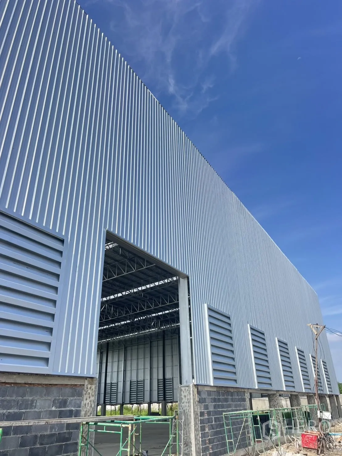 Factory for rent in Mueang Samut Prakan, Samut Prakan - Exterior view showing a large loading bay opening with metal cladding and louvered vents.
