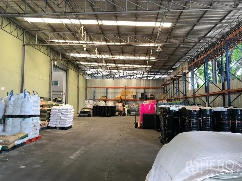 Factory for rent or sale in Khlong Luang, Pathum Thani - High-bay warehouse with pallet racks and wide drive-through access.