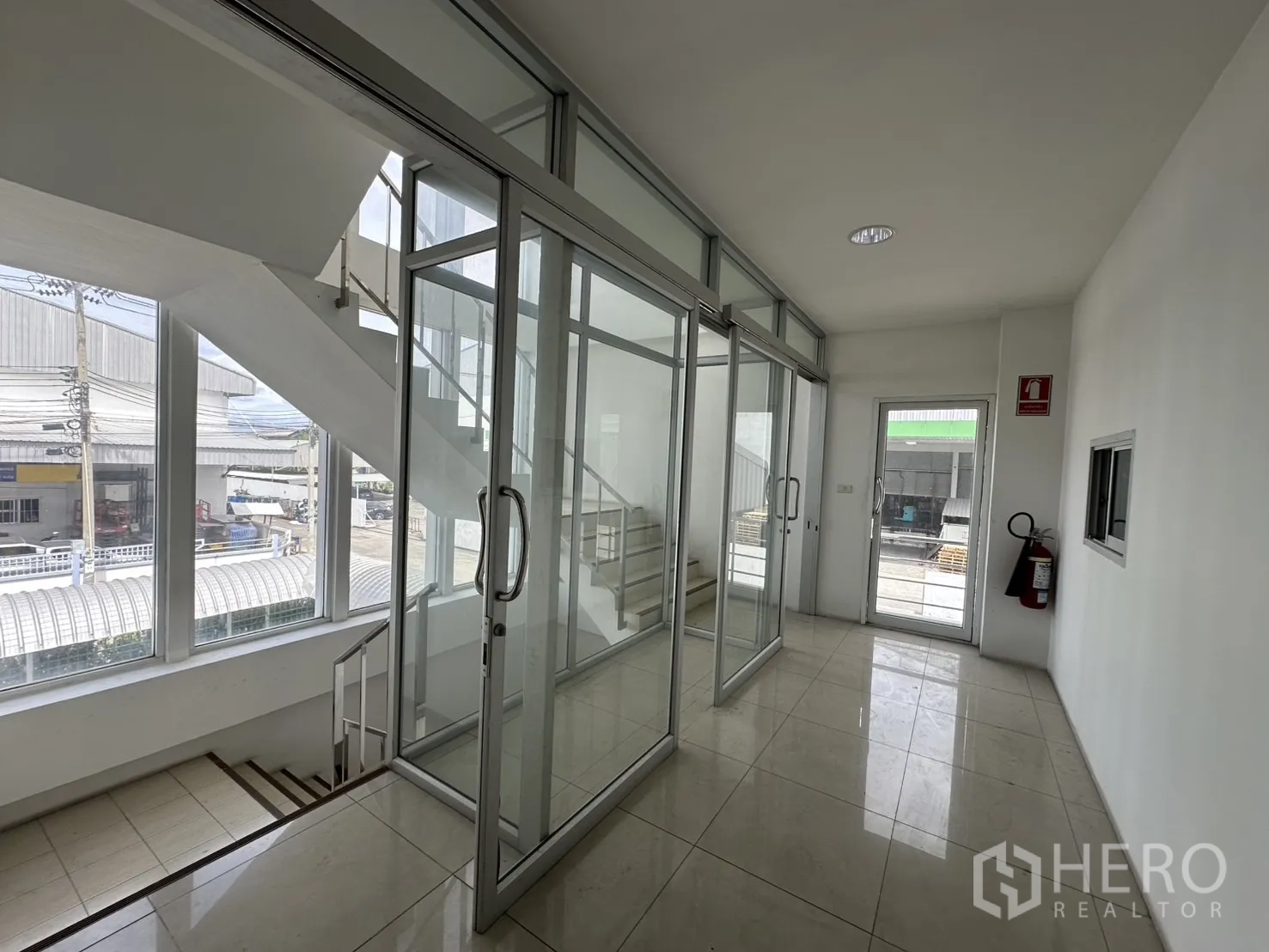 Factory for rent - Bright glass-partitioned corridor by the staircase overlooking the estate.