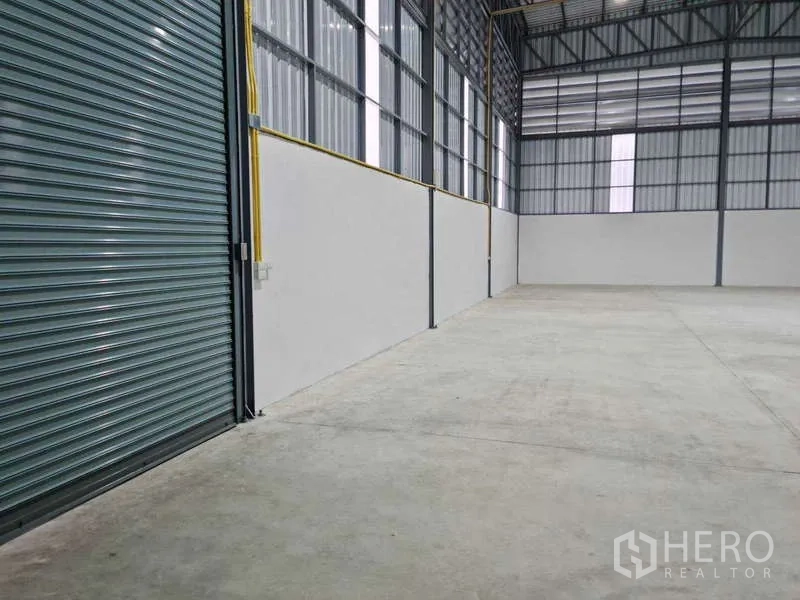 Warehouse for rent in Bang Bua Thong, Nonthaburi - Warehouse aisle view with high windows, ventilation louvers and smooth concrete floor.