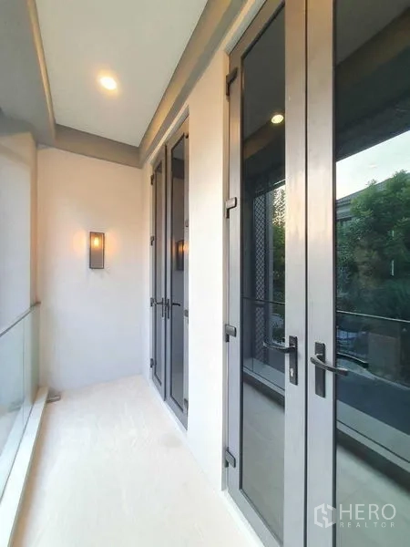Detached House for sale in Prawet, Bangkok - Covered balcony with glass railing and tall French doors.