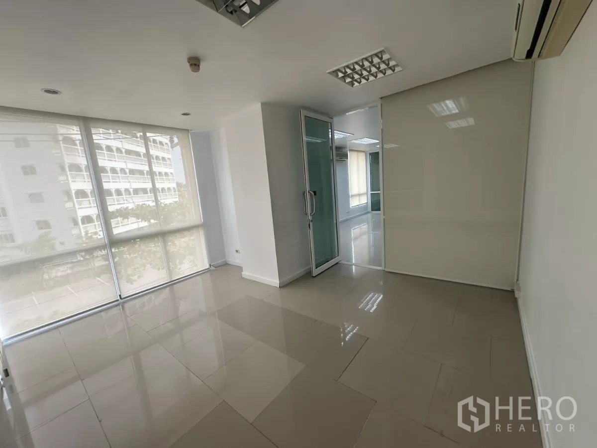 办公空间 出租在Huai Khwang, Bangkok - 采光充足的转角办公室，落地窗与玻璃门并设卷帘。