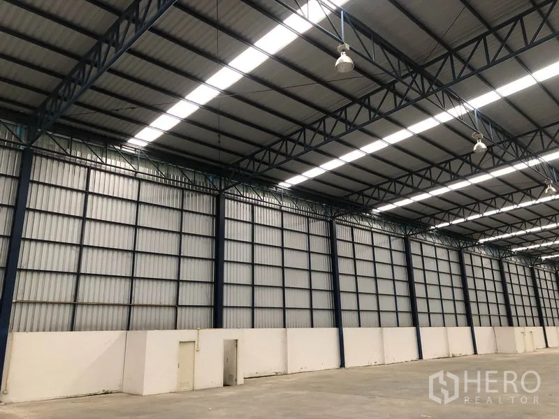 Factory for rent or sale in Phra Nakhon Si Ayutthaya - Side wall detail of the warehouse showing insulated panels, lighting, and personnel doors.