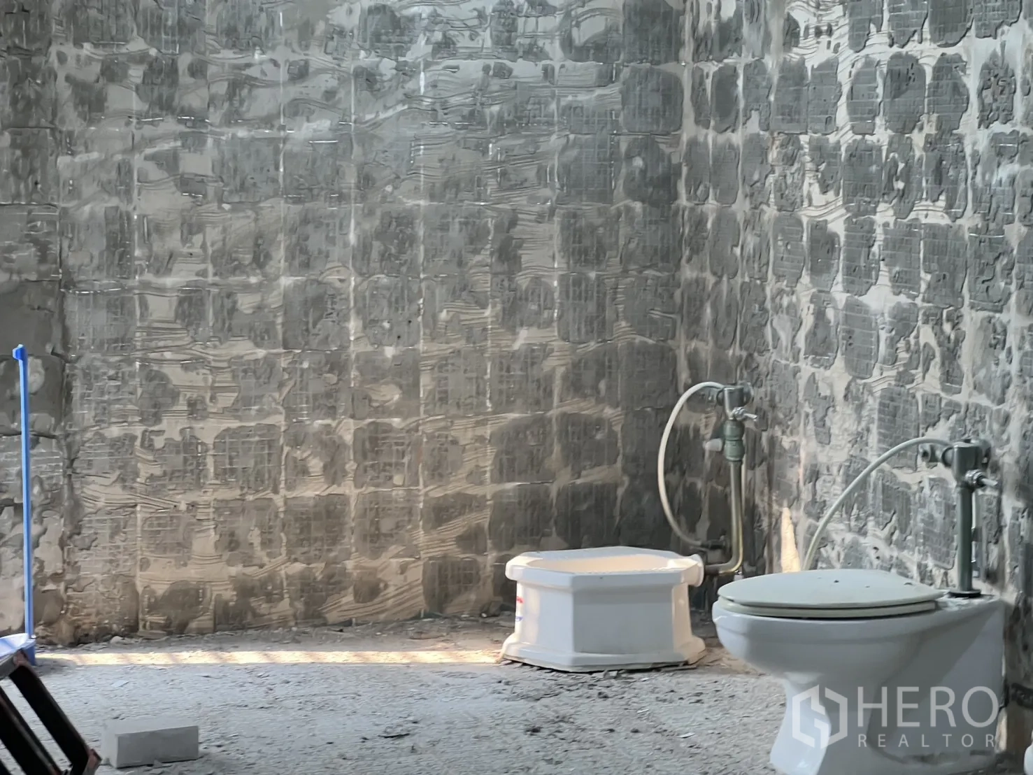 Office Space for rent in Watthana, Bangkok - Restroom area under renovation with floor fixtures and unfinished concrete walls.