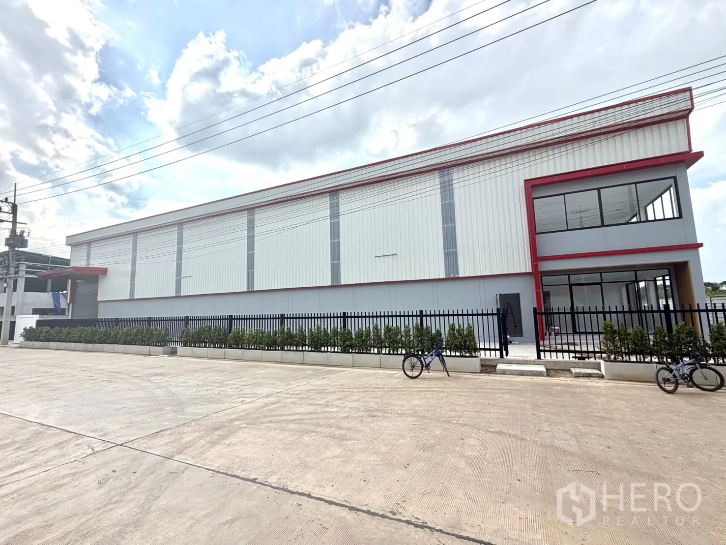 โรงงาน for rent or sale in Lam Luk Ka, Pathum Thani - ภายนอกโรงงานพร้อมอาคารสำนักงานมุมกระจกและพื้นที่ปลูกต้นไม้ด้านหน้า