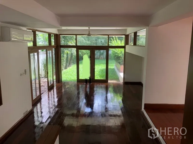 Detached House for rent in Watthana, Bangkok - Bright living room with floor-to-ceiling windows overlooking the garden.