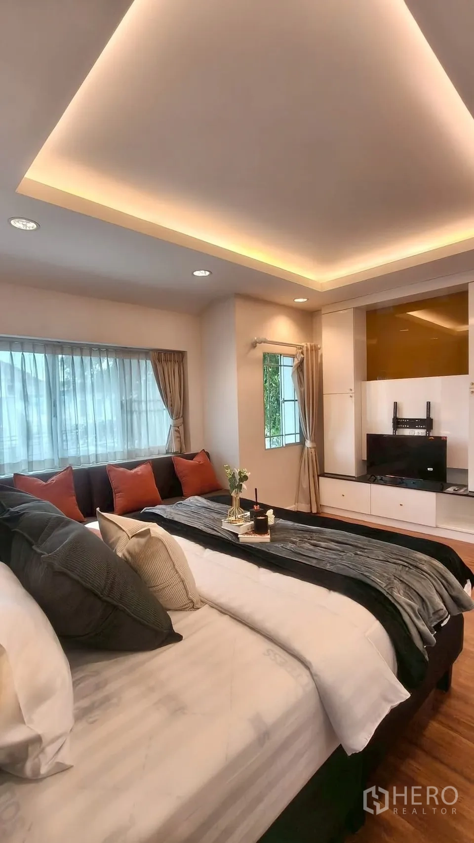 Detached House for rent or sale in Mueang Samut Prakan, Samut Prakan - Cozy master bedroom with cove ceiling lights, large bed, TV unit and curtained windows.