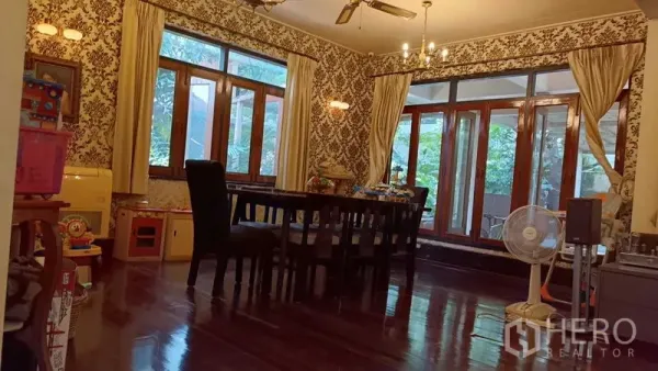 Detached House for rent in Phaya Thai, Bangkok - Formal dining room with polished wood floors, chandelier, patterned wallpaper and wide windows.